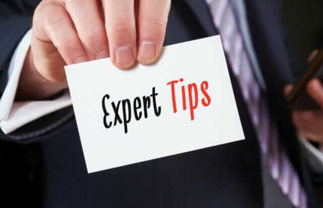 A businessman holding a business card with the words, Expert Tips, written on it. How to get more website traffic